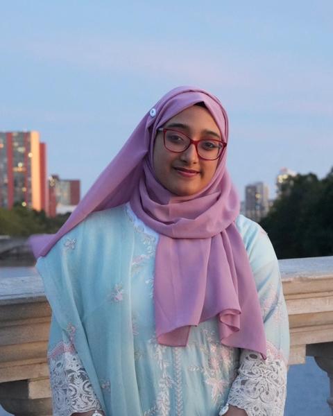 Student posing on a bridge